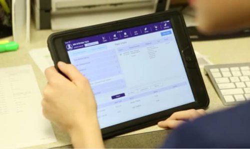 person's hands holding tablet